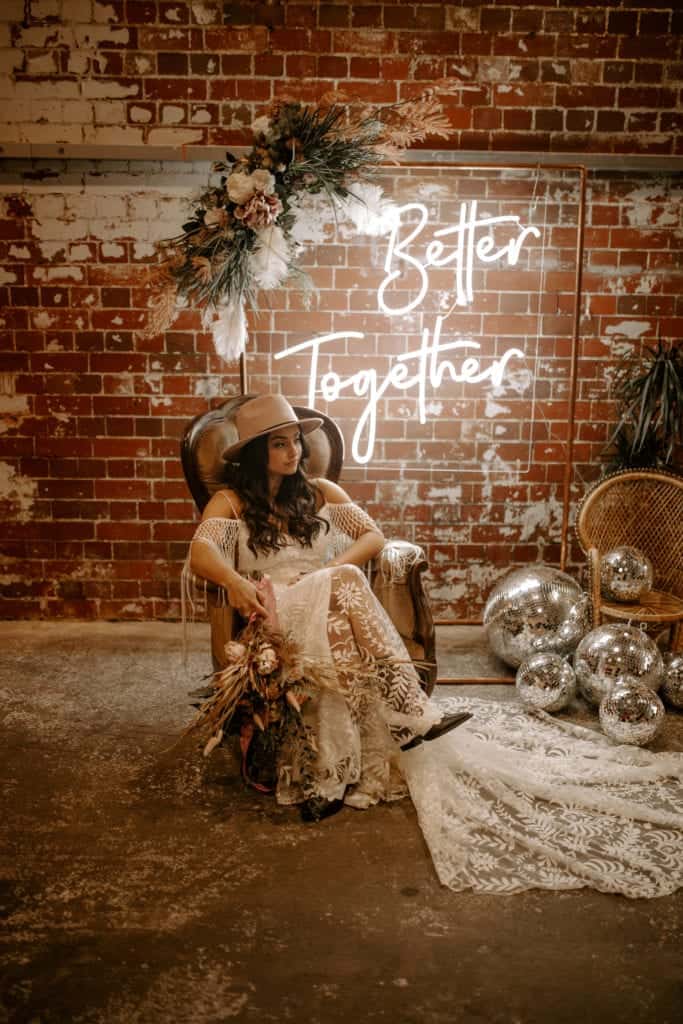 bride in a chair with neon sign