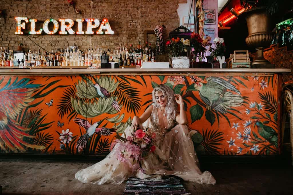 urban bride sat on floor with plunge wedding dress neckline