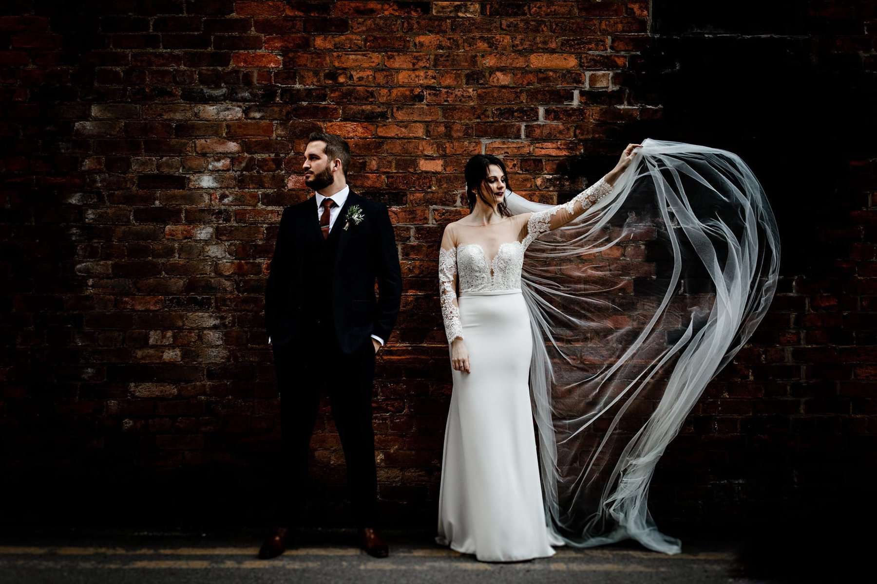 wedding couple and a brick wall 