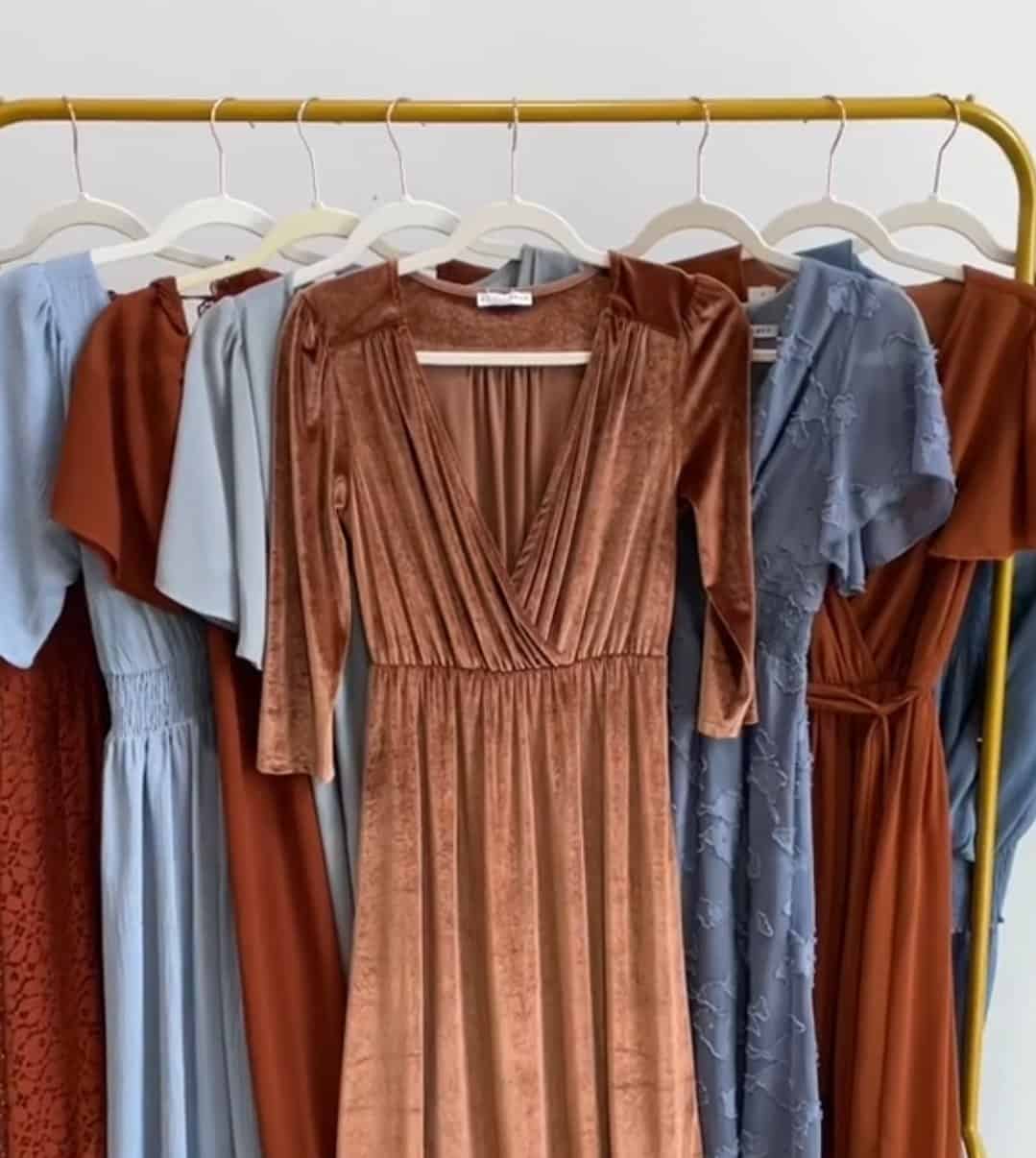 copper and dusty blue bridesmaid dresses hung together