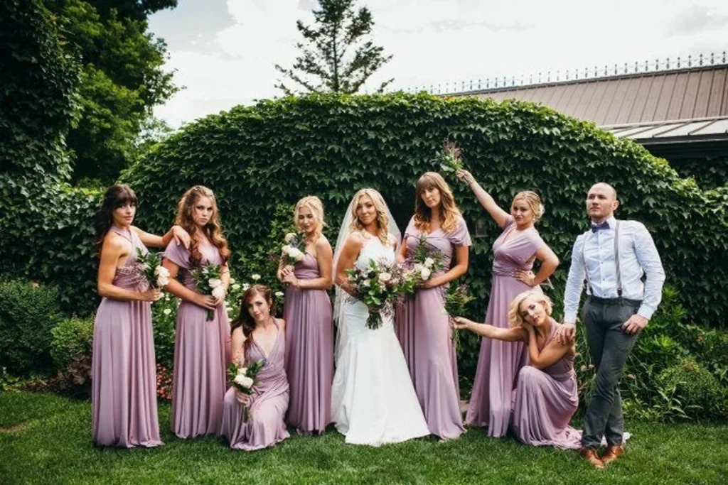 bridesmaid in multi way lilac dresses with bride and groom posing