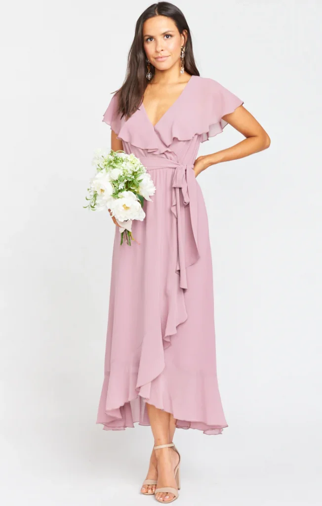 bridesmaid with bouquet wearing a lilac wrap dress with ruffle sleeves