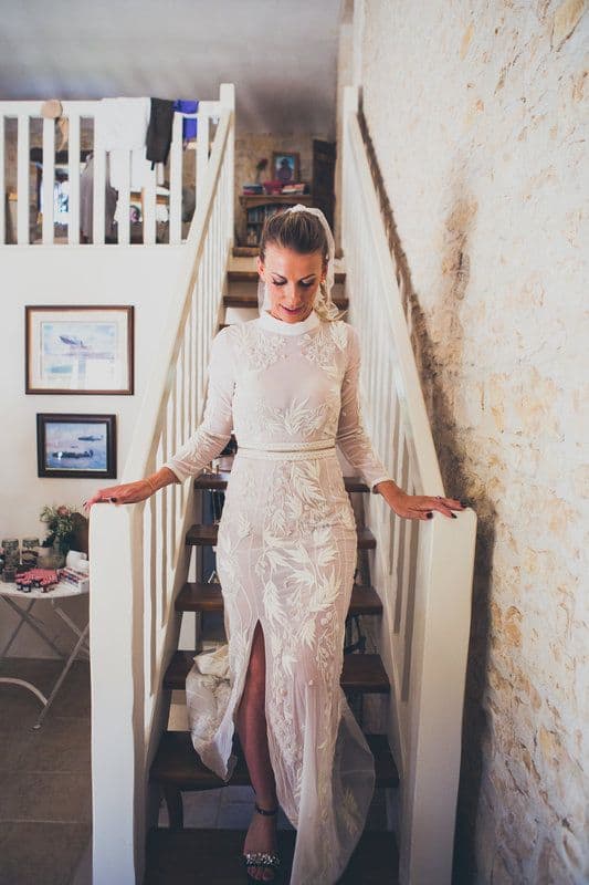 bride walking down stairs on her wedding day, wearing a long sleeve lace dress