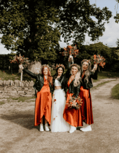 bride and three bridesmaid in satin burnt orange dresses