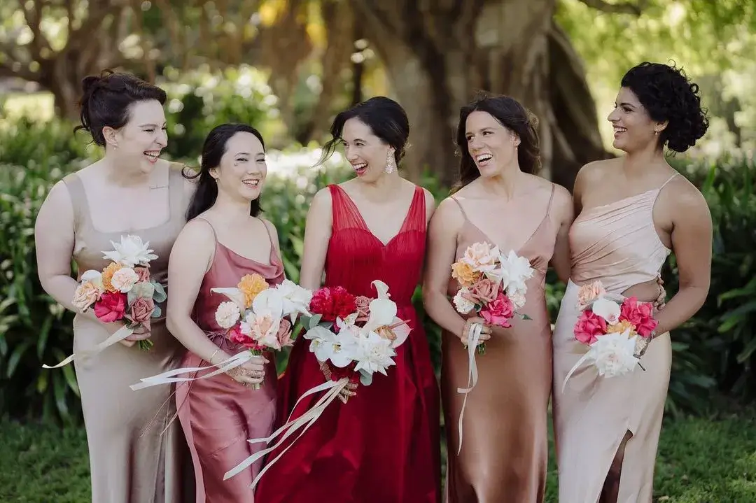 bride in red dress with bridesmaid is mismatched pinks 