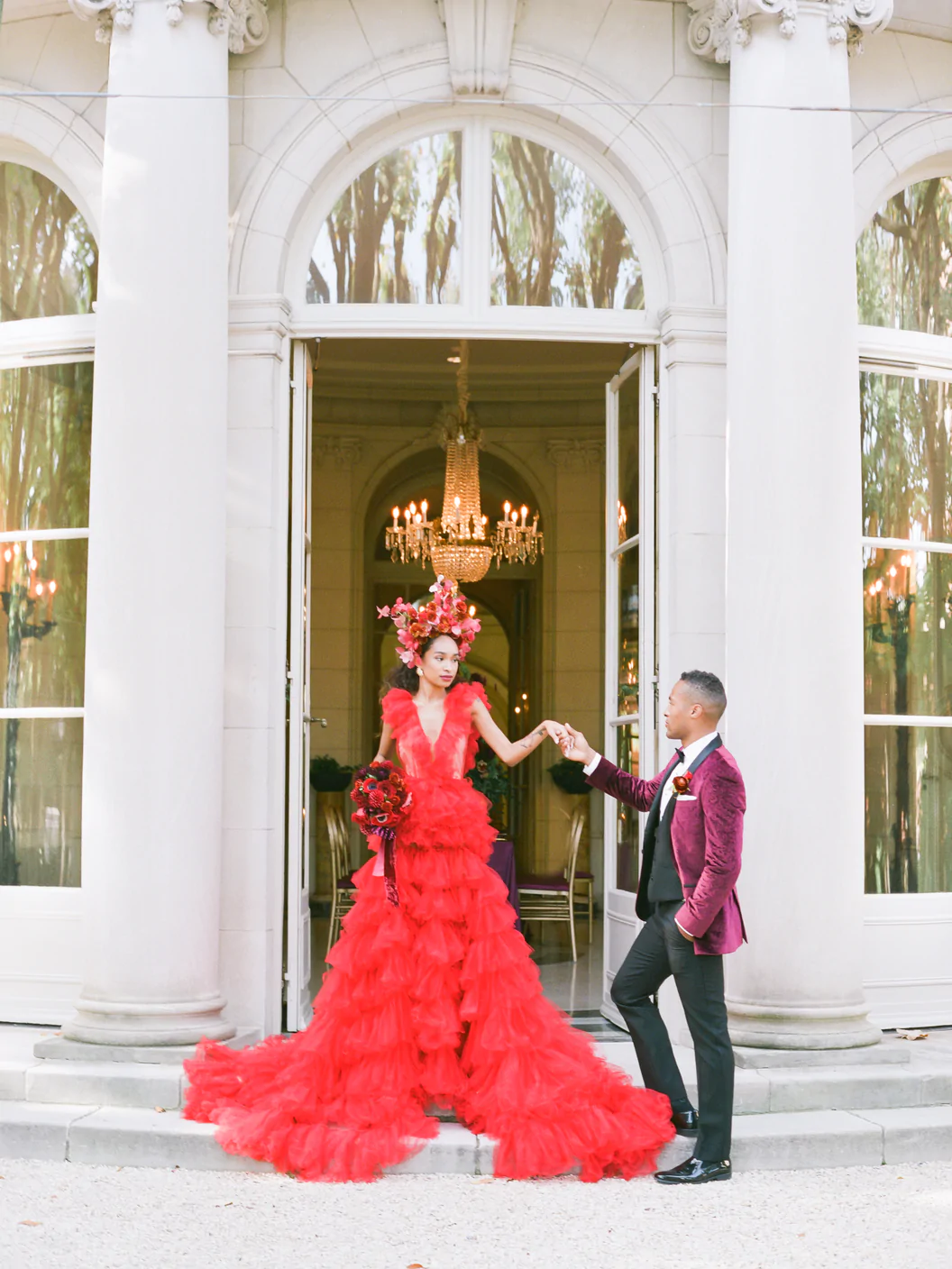 ruffled red wedding dress. bride and groom on steps