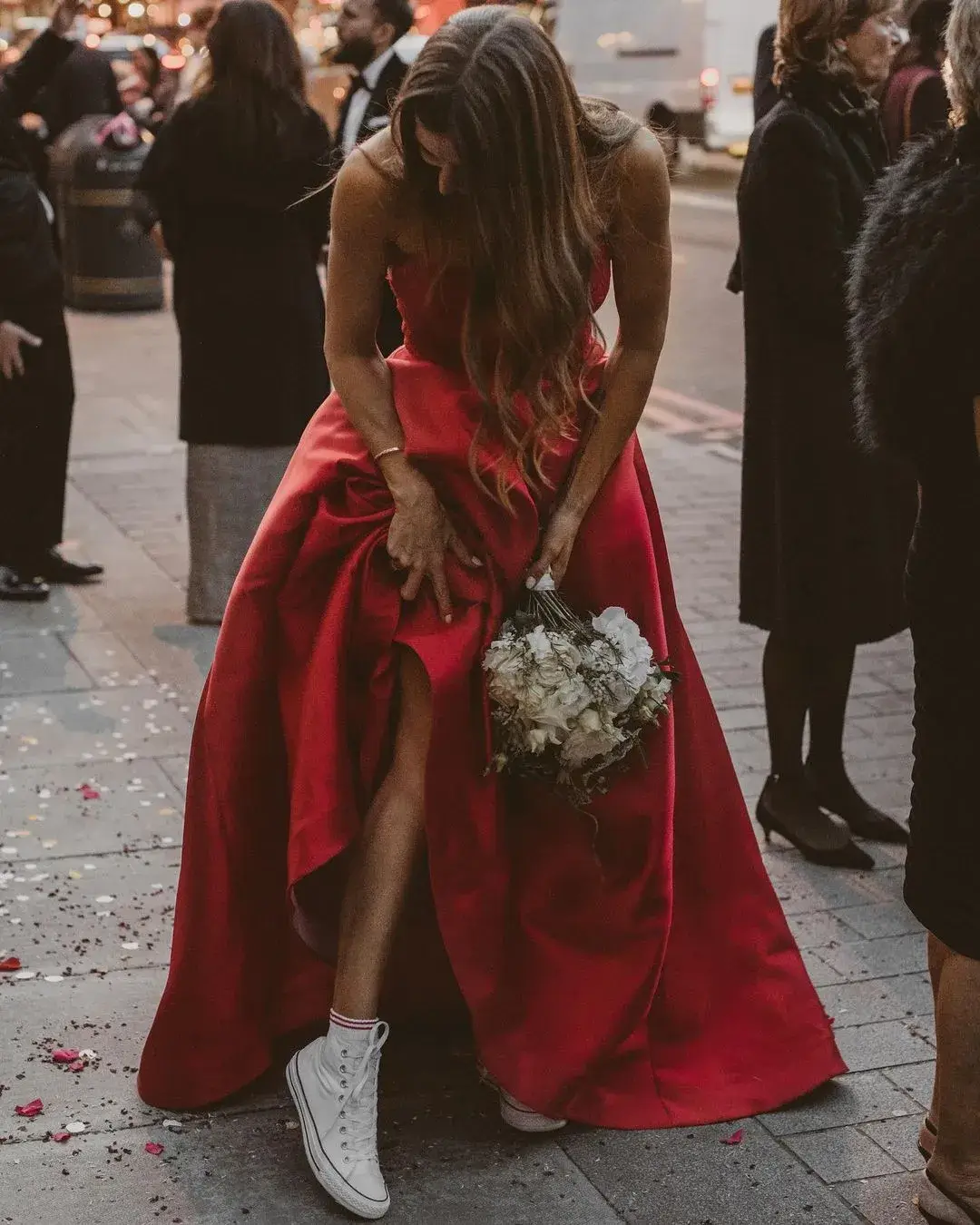 bride in red dress with white sneakers and white bouquet