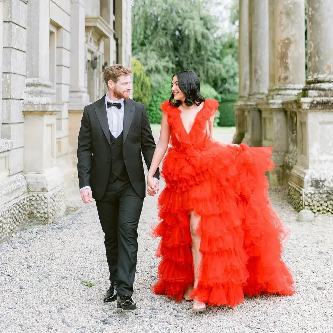 groom with bride in tulle high split red wedding dress with neutral shoes 