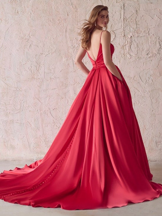 bride in red dress with hands in her pockets