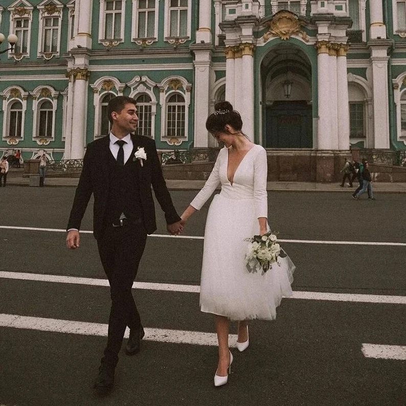 Bride and groom on city centre street holding hands