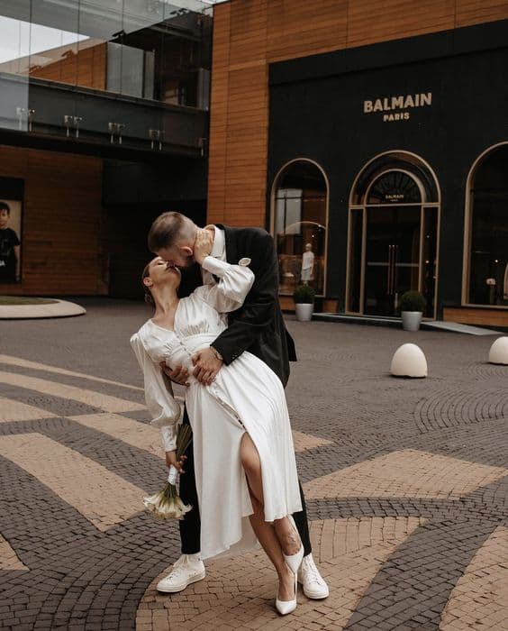 bride and groom on city street bride in midi wedding dress