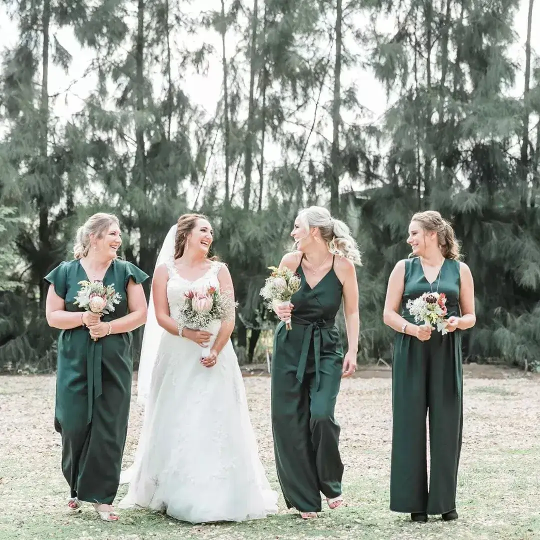bride and bridesmaid in green jumpsuits