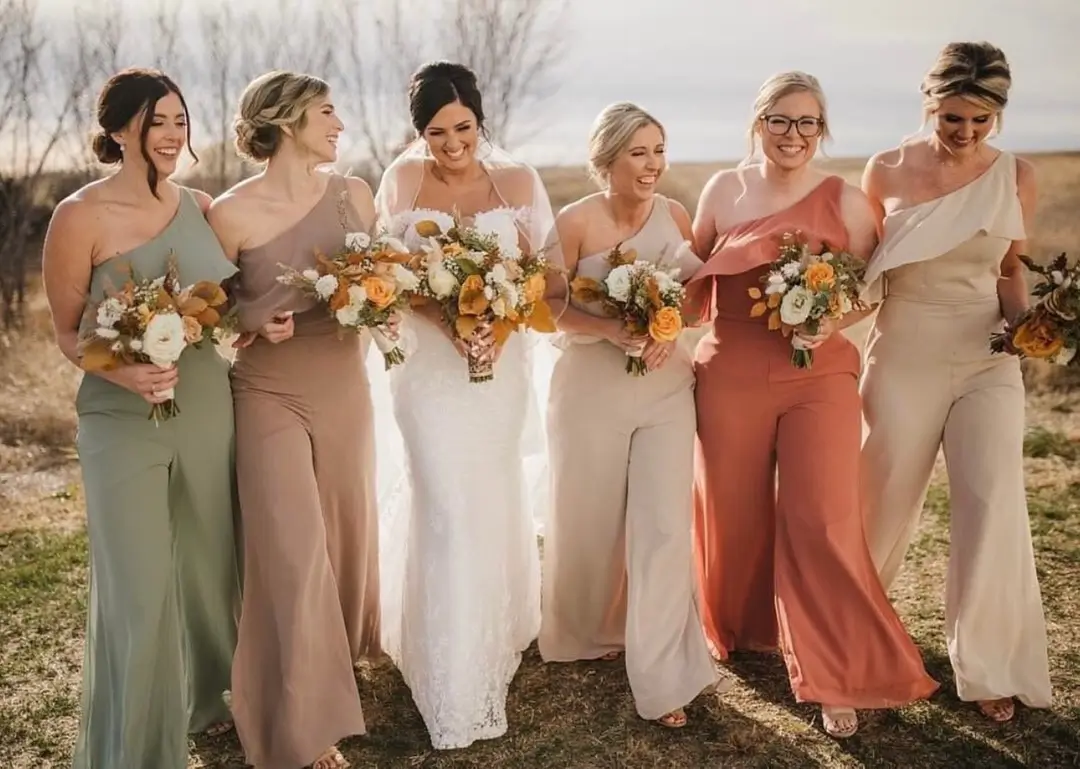 bride and bridesmaid in mismatched coloured jumpsuits