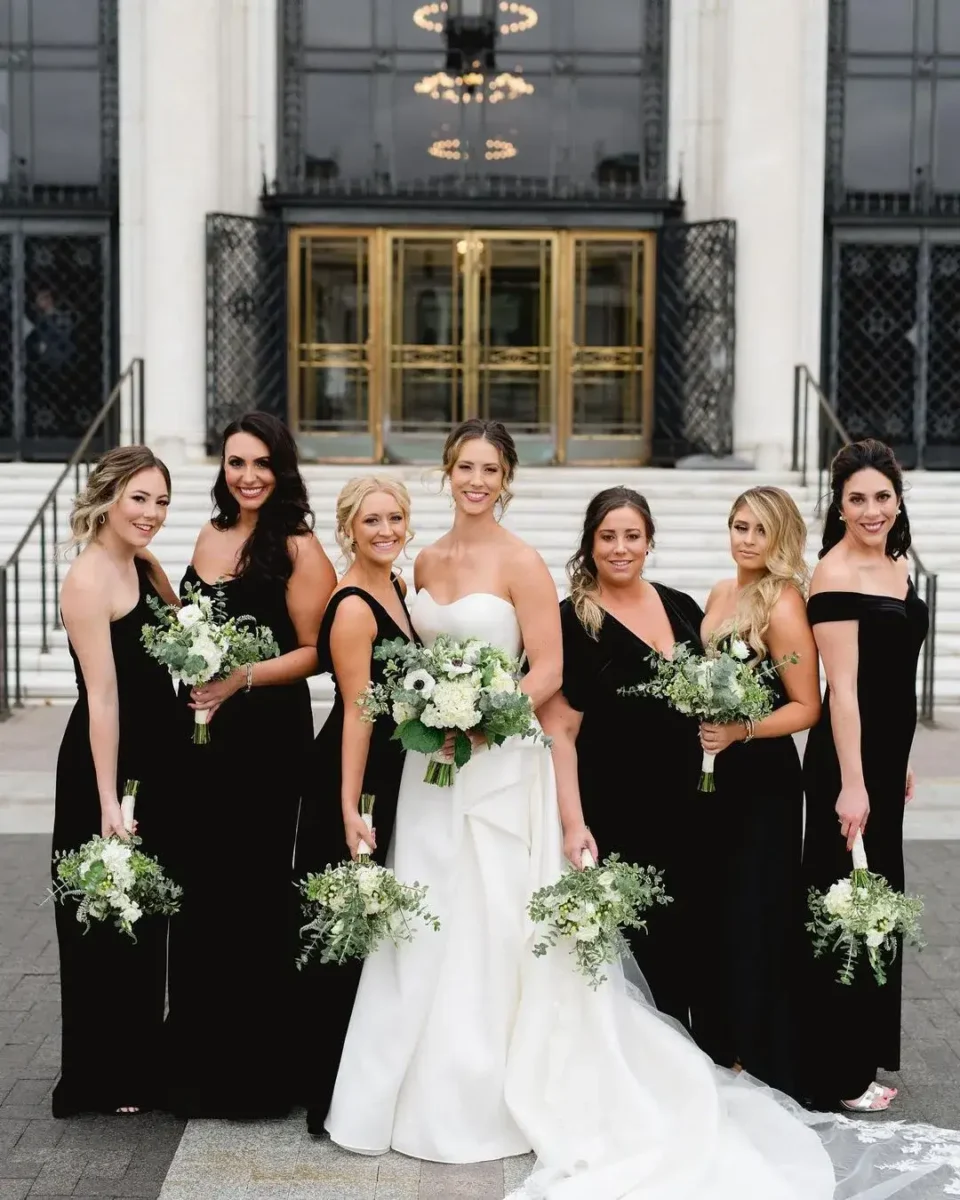 bride and bridesmaid in black velvet dresses and green bouquets 