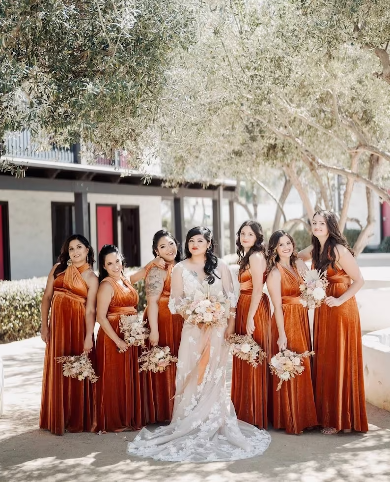 bride and bridesmaid in burnt orange velvet dresses