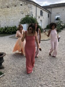bridesmaid in coral bridesmaid dress with 3 other bridesmaid in matching colours
