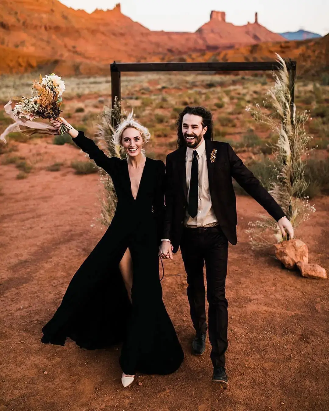 bride and groom in black in their desert wedding 