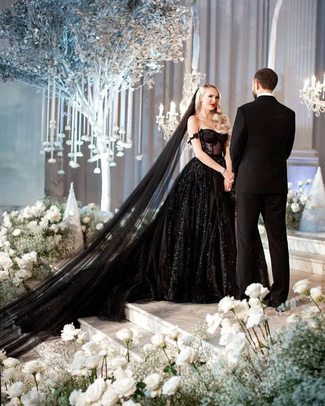 bride and groom at alter in black dress with long black veil 