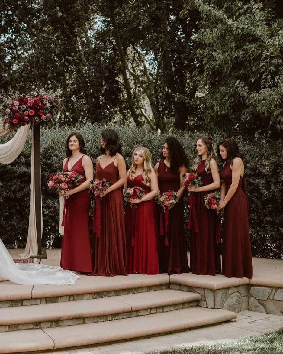 bridesmaid stood at alter all in dark red bridesmaid dresses