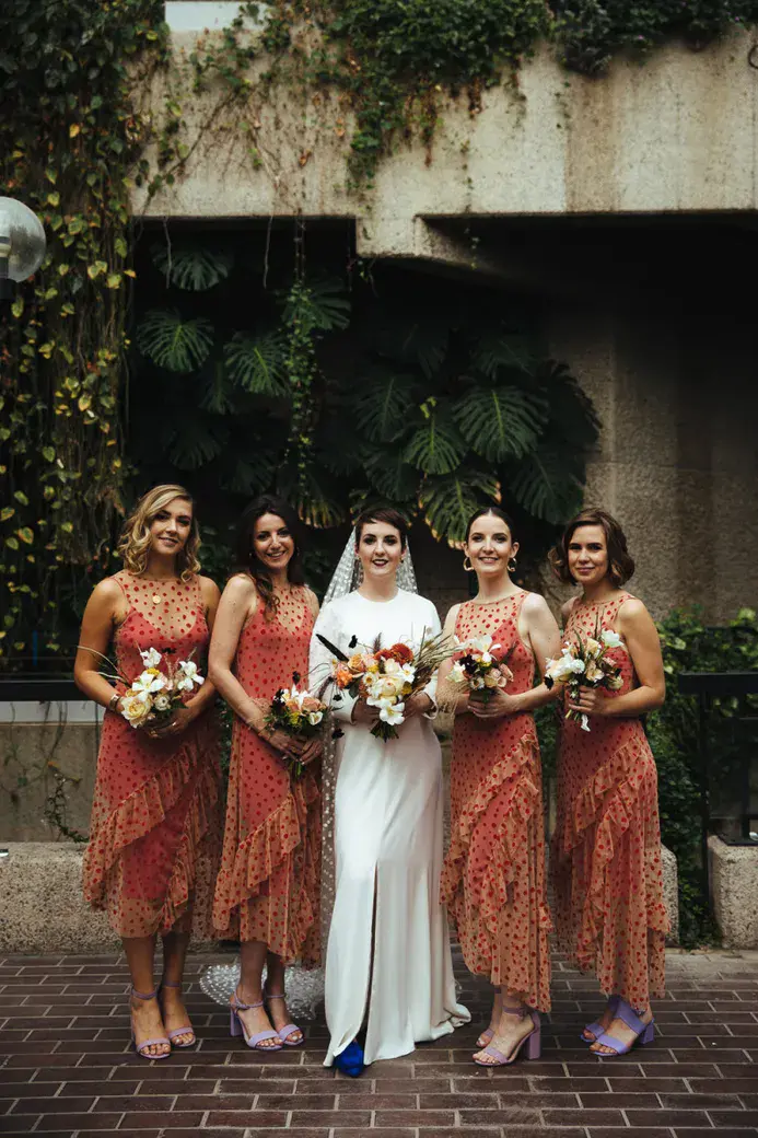 bride with bridesmaid in orange polka dot dresses