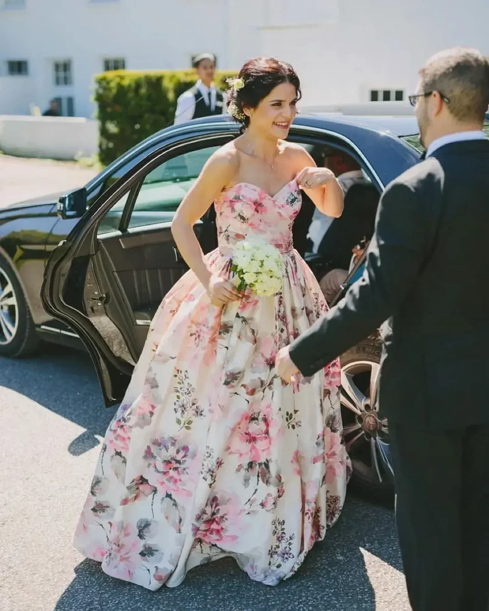 bride getting out of car in a floral wedding dress
