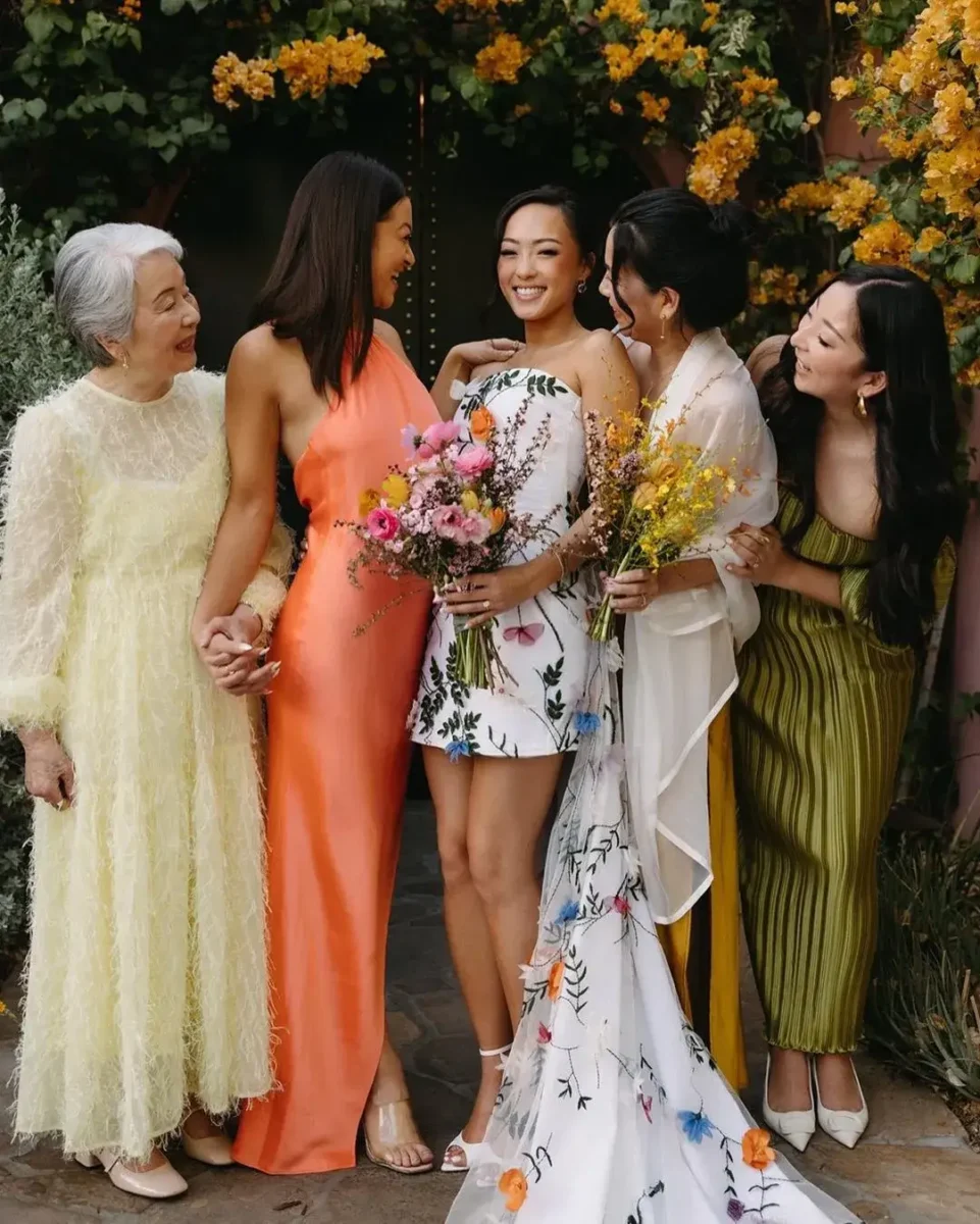 bride in high low floral wedding dress with mismatched bridesmaids 