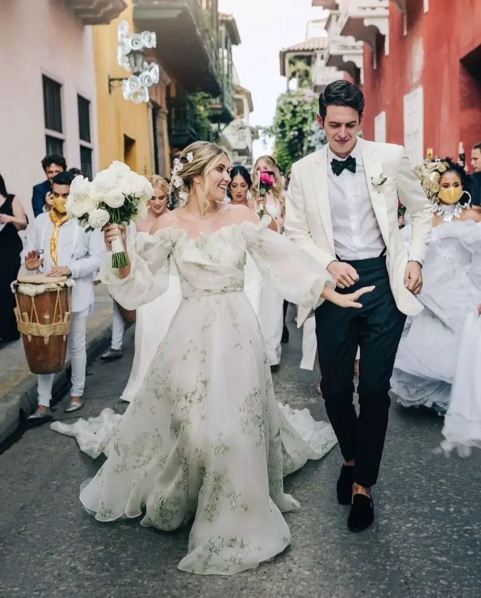 couple and guest walking dow the street - bride in floral dress