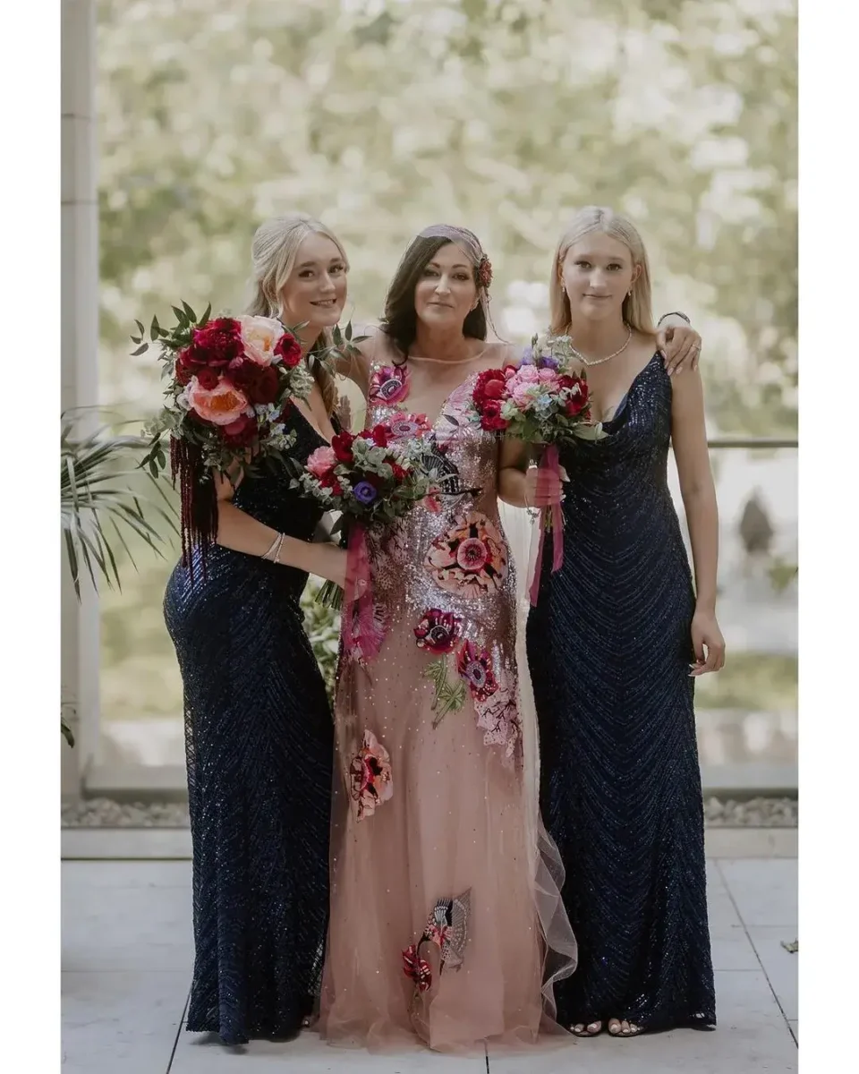 bride in floral dress with bridesmaids innavy dresses