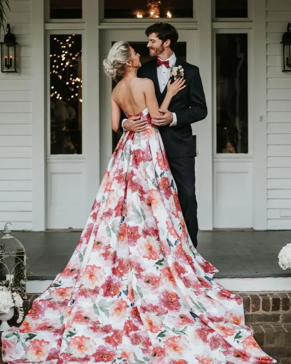 bride in bright bold pink floral dress stood with groom