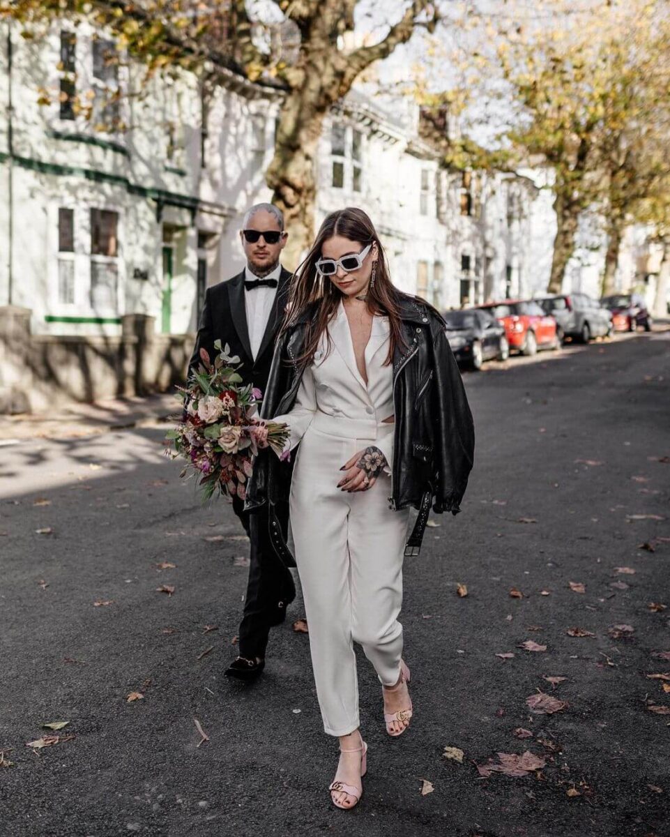 groom and bride on a city street, bride in a jumpsuit and a leather jacket