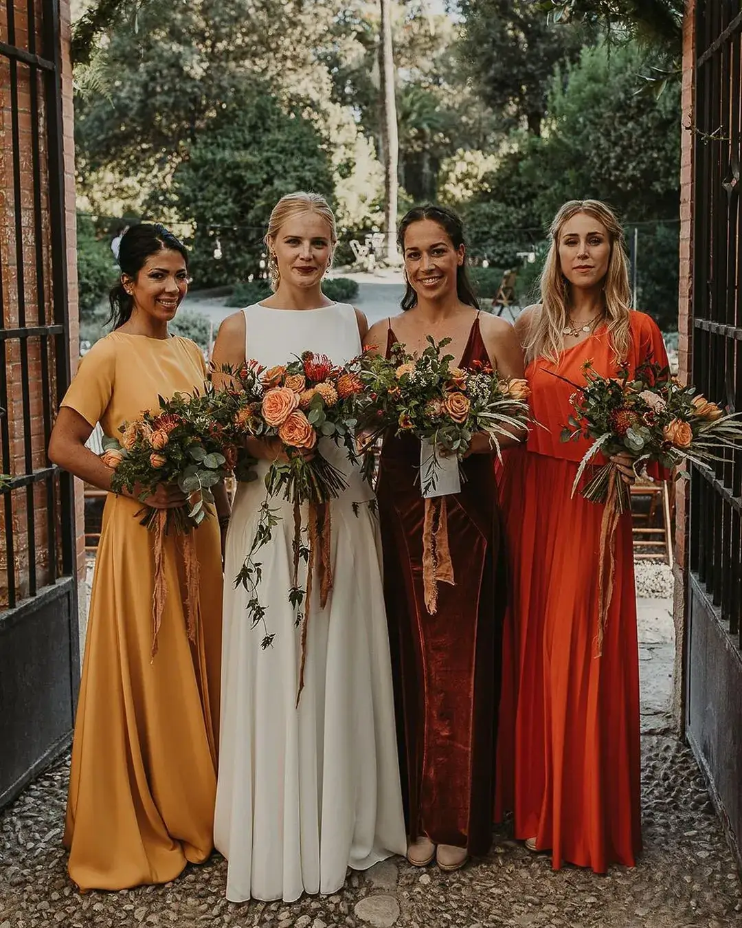 bride with bridesmaids in autumn coloured mismatched bridesmaid dress