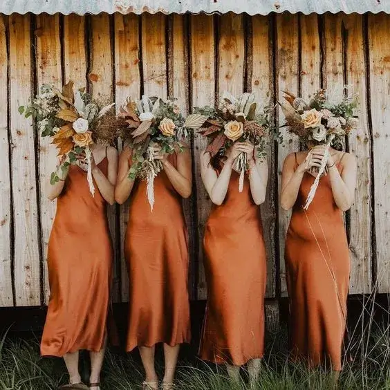 bridesmaid in slip copper dresses with boho wild bouquets 