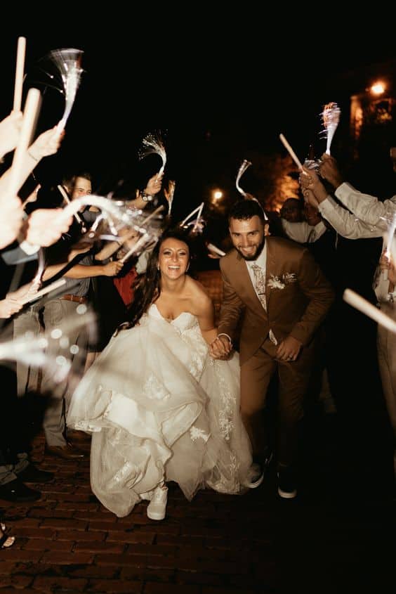 bride and groom running through glow sttiks