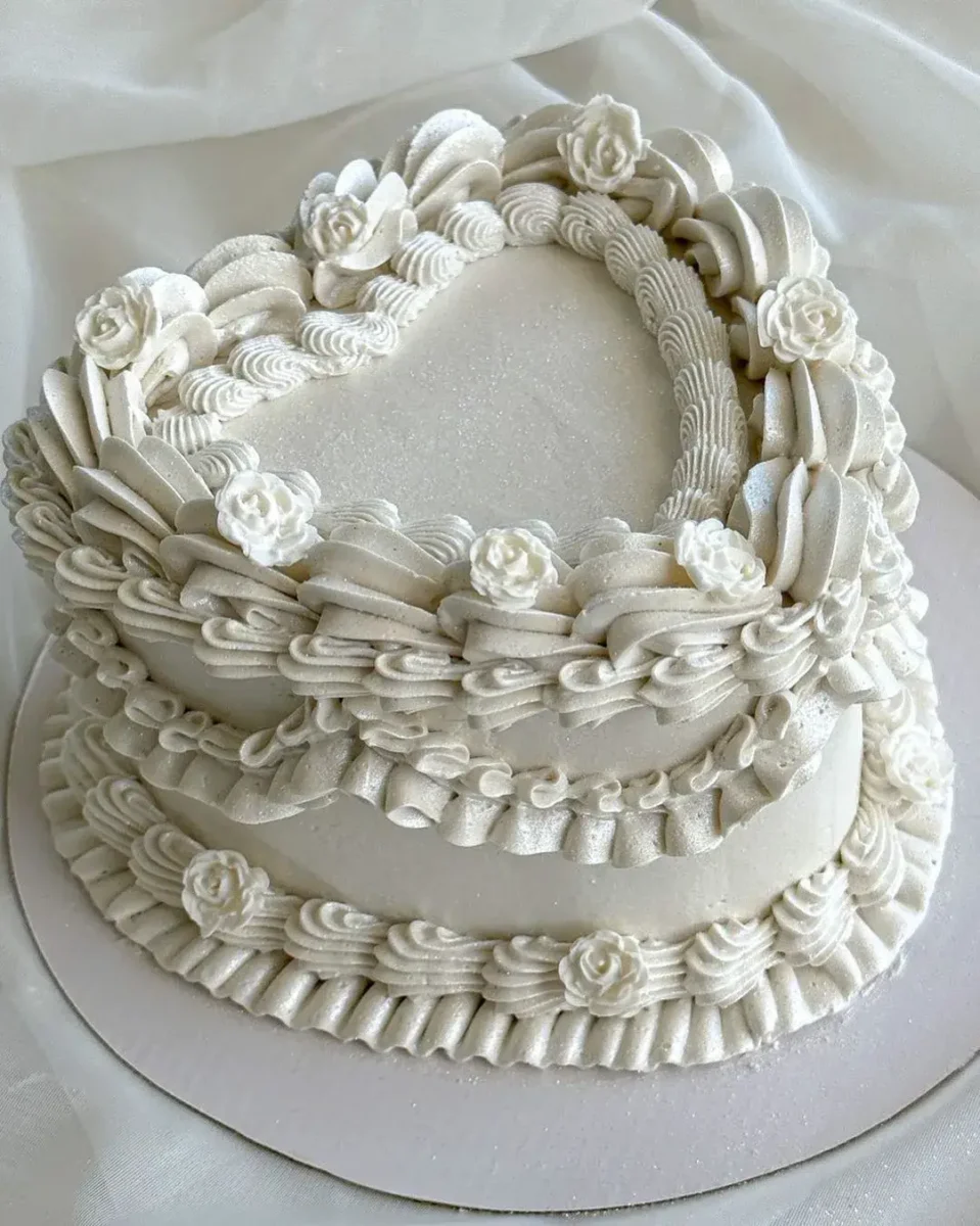heart shape white cake with lambeth piping