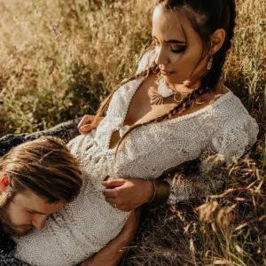 bride in pagan dress with groom lay on grass