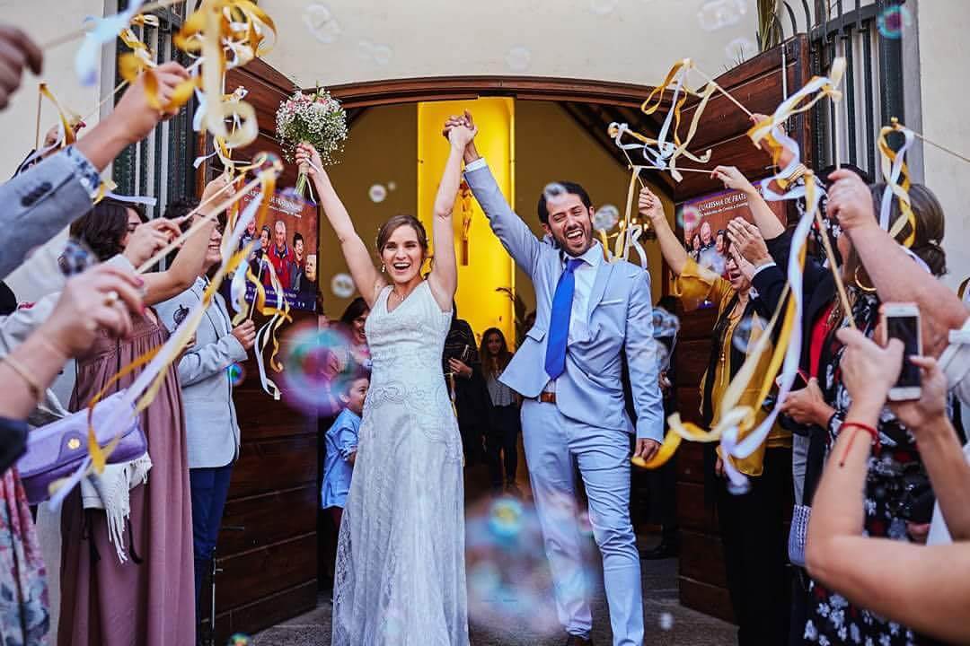 couple cheering while guest wave bells and wands around them.