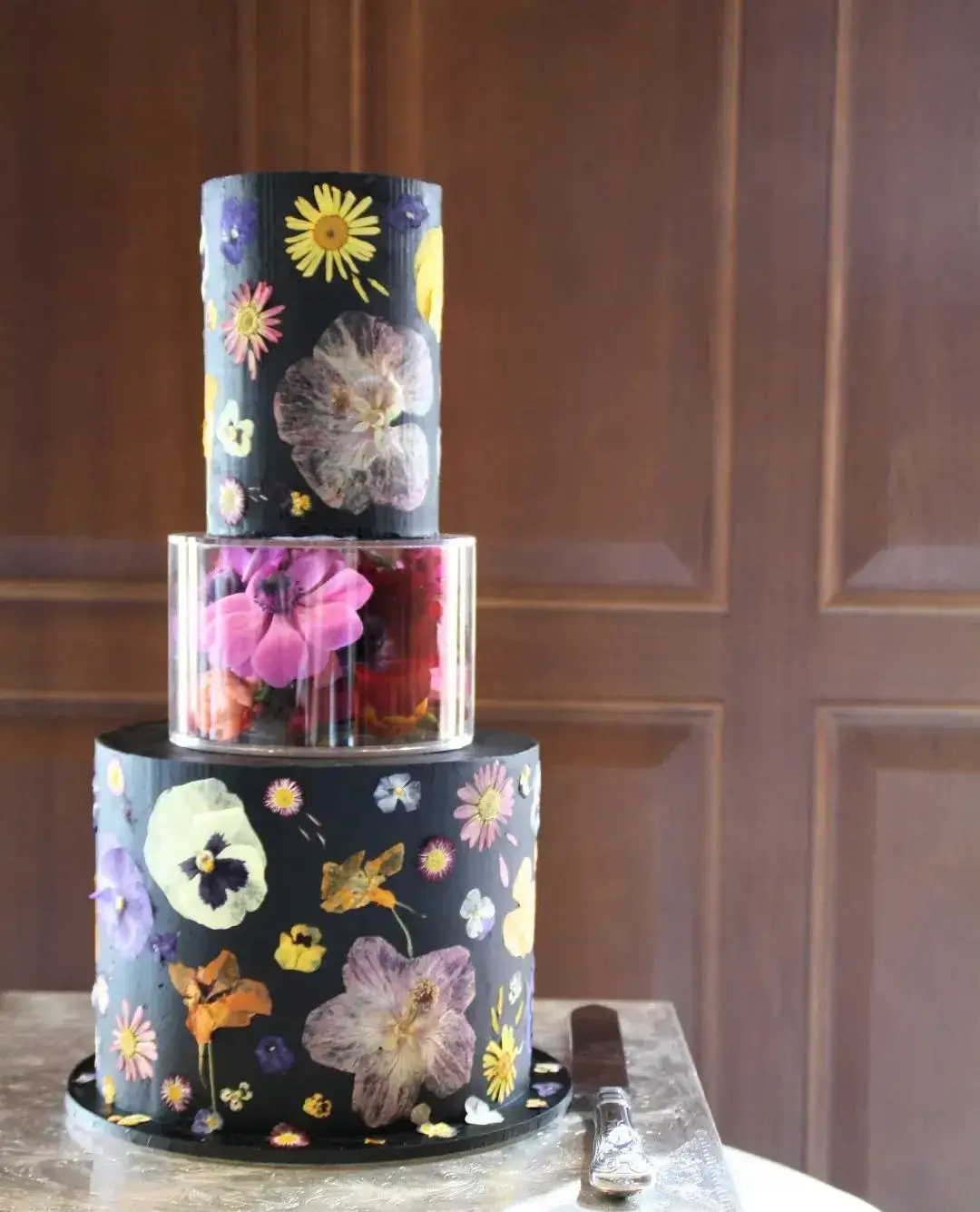 black cake with pressed flowers all over 