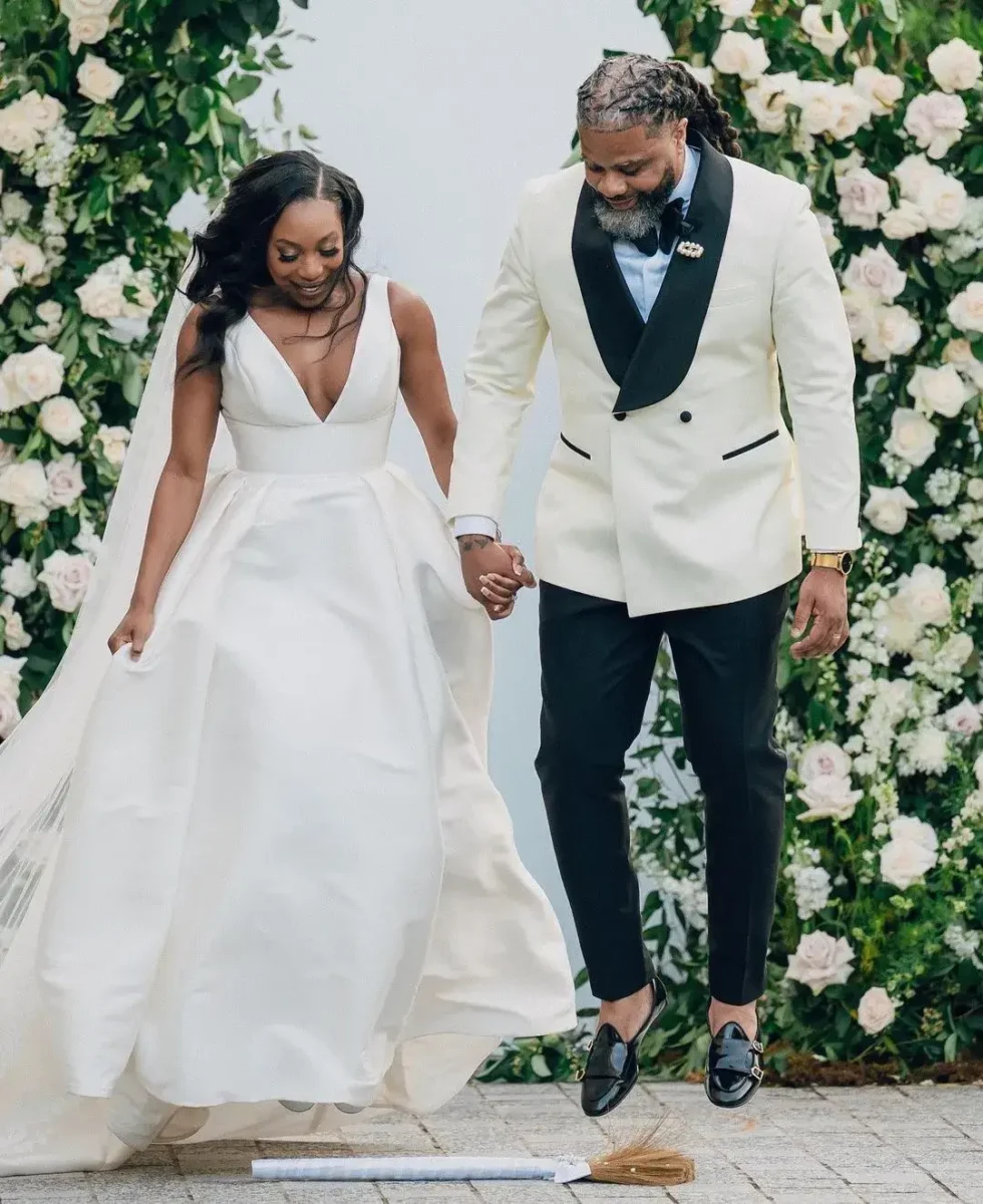 couple jumping the broom at ceremony