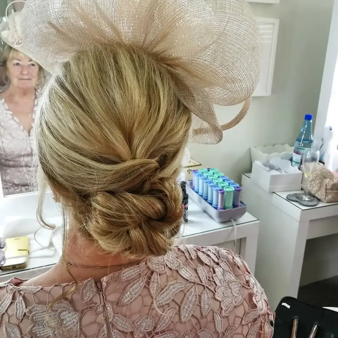 back view of a mother of the brides hair in a bon and wearing a fascinator 