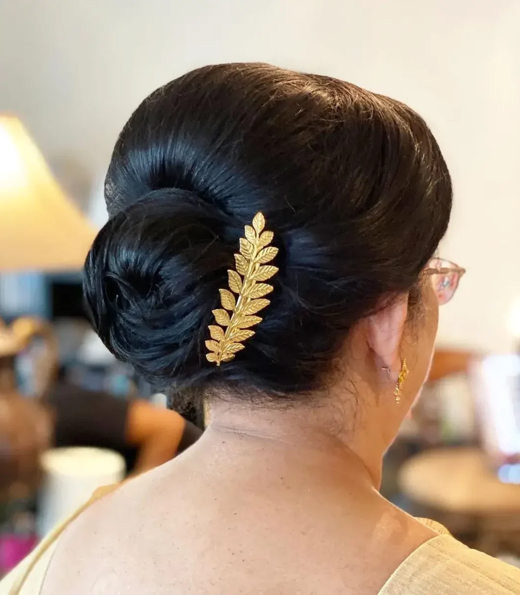 back view of hair in a tight bun and a gold side clip