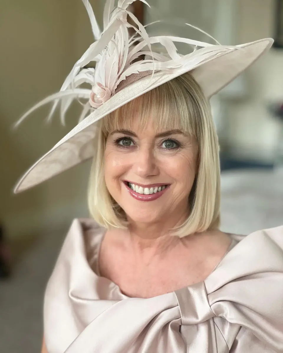 short mother of the bride hair in a straight bob and wearing a hat