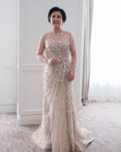 mother of the bride in a long sleeve sequin dress in light gold