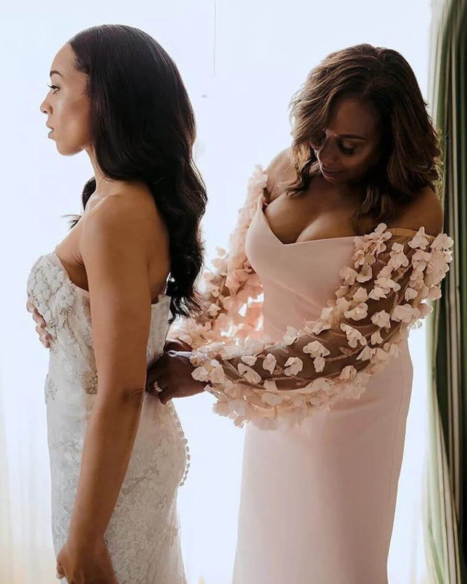 mother helping bride with dress, mother in pink dress with puffed embellished sleeves