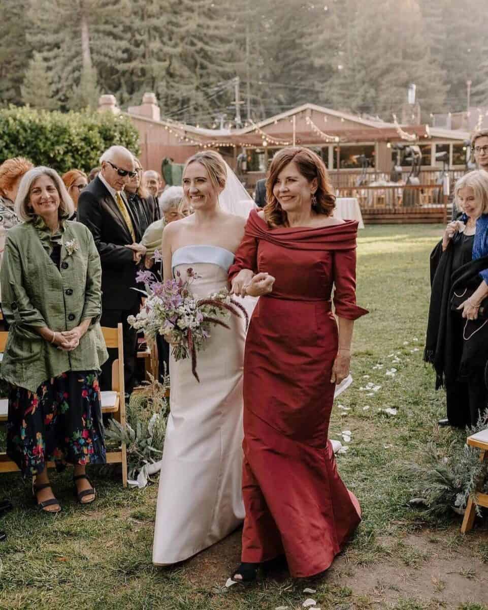 mother and bride walking down the aisle, mother in red dress off the shoulder 