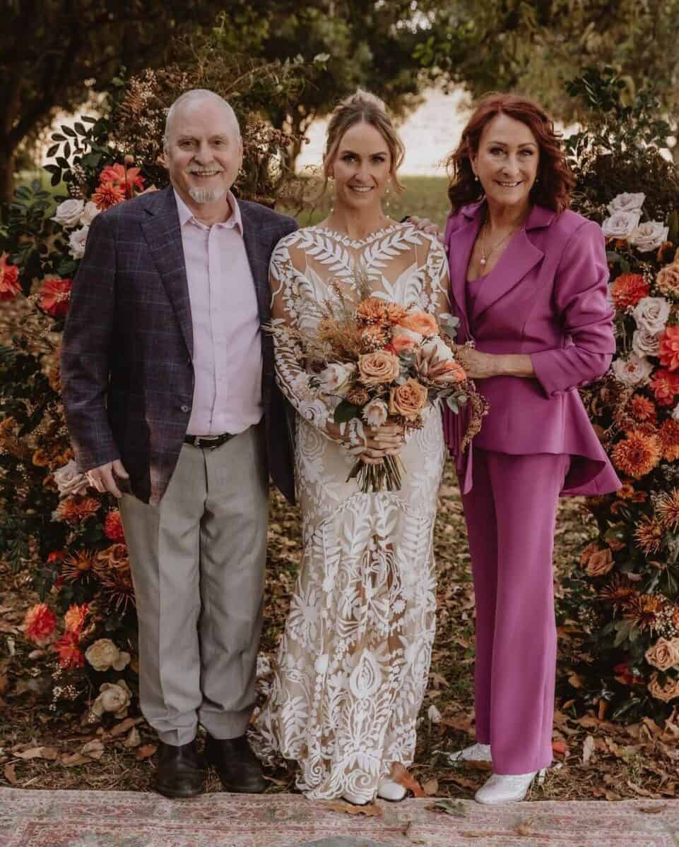 bride with father and mother, mother in pink trouser suit