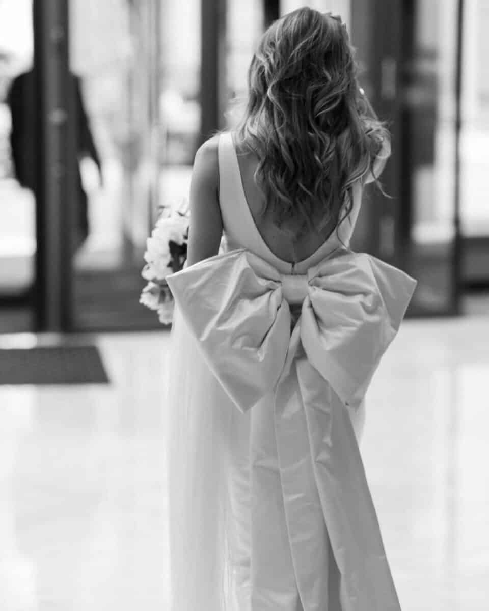 bride in simple dress with big bow on the back