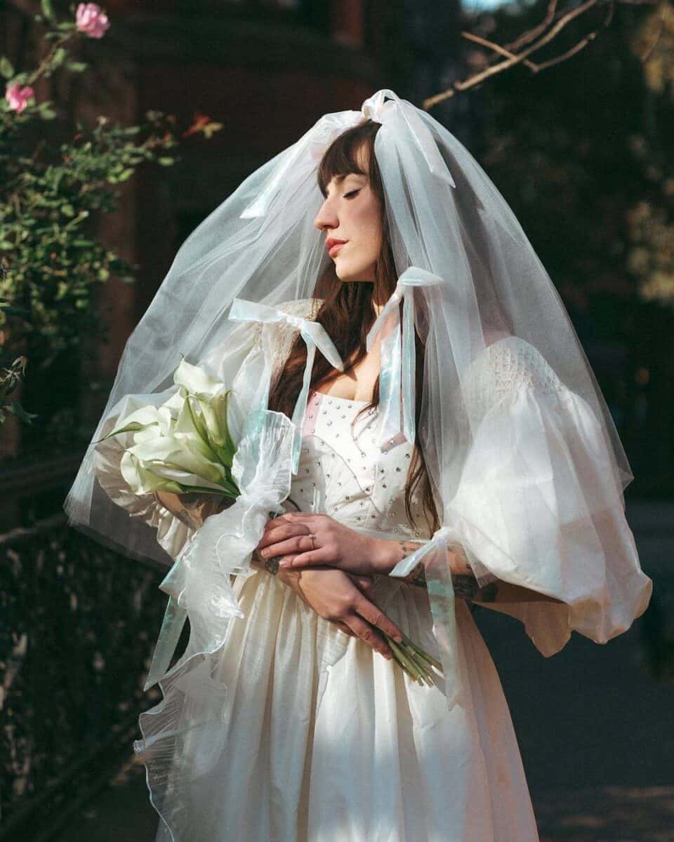 bride in a big puffy veil with little bows added all over 