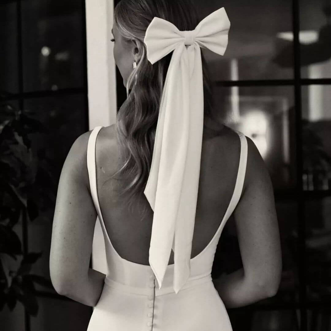 bow in bride's hair with long tassels hanging down 