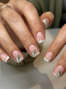 nails painted with white and green florals