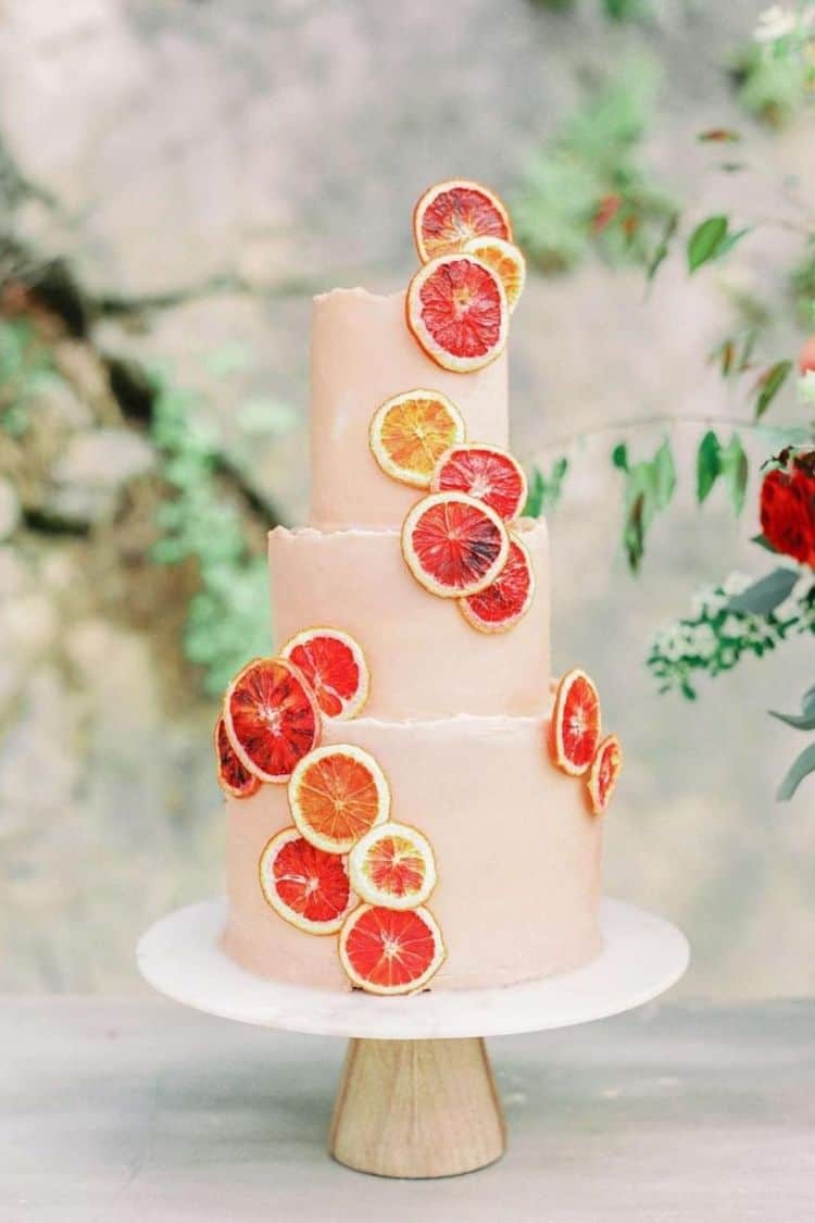 peach summer wedding cake with sliced oranges 